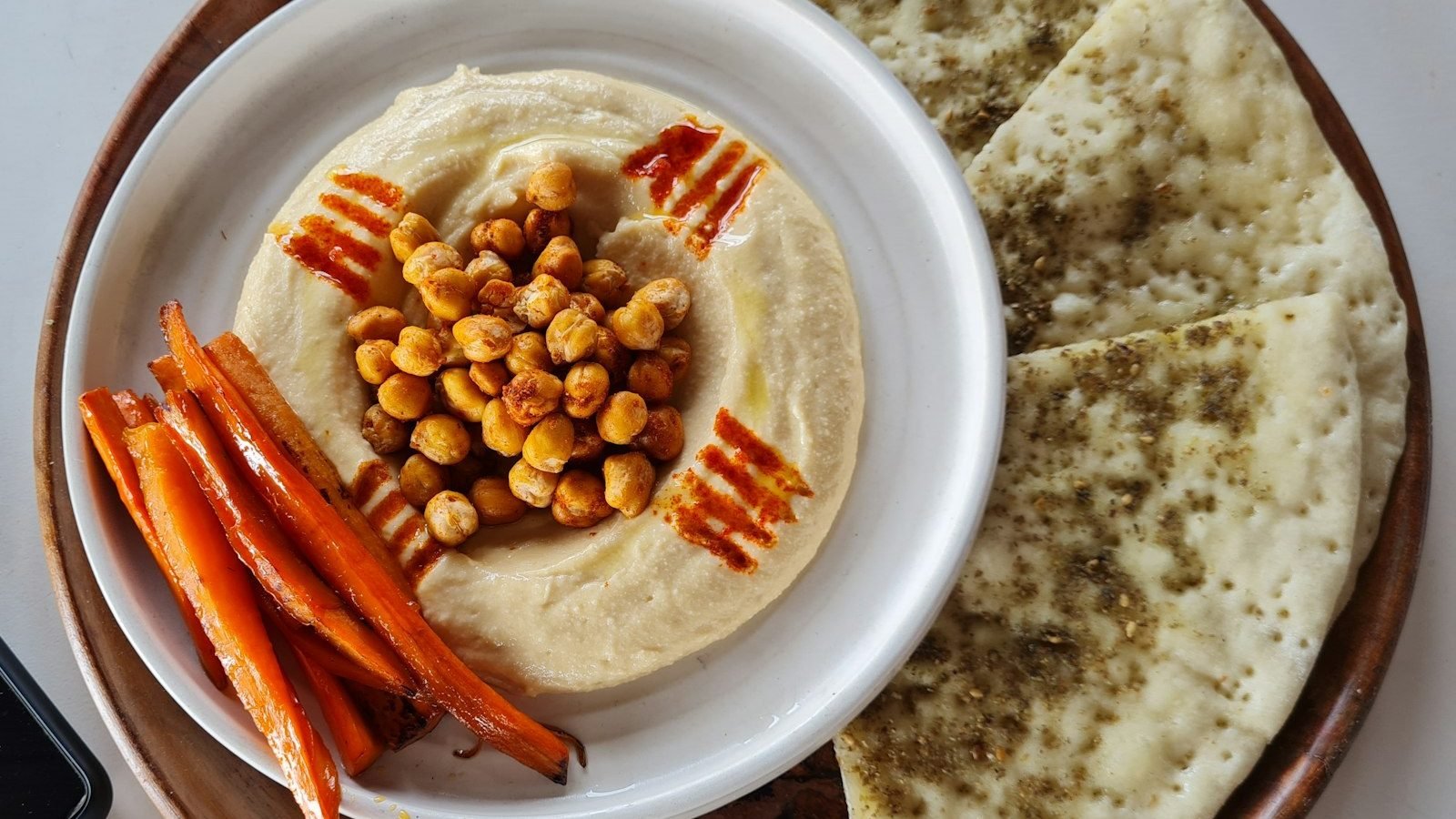 A plate of hummus with carrots and pita bread, a simple healthy snack
