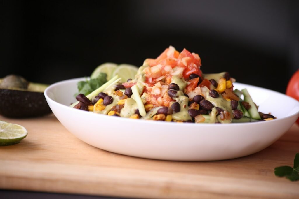 Bowl of rice topped with black beans, corn and fresh tomato salsa