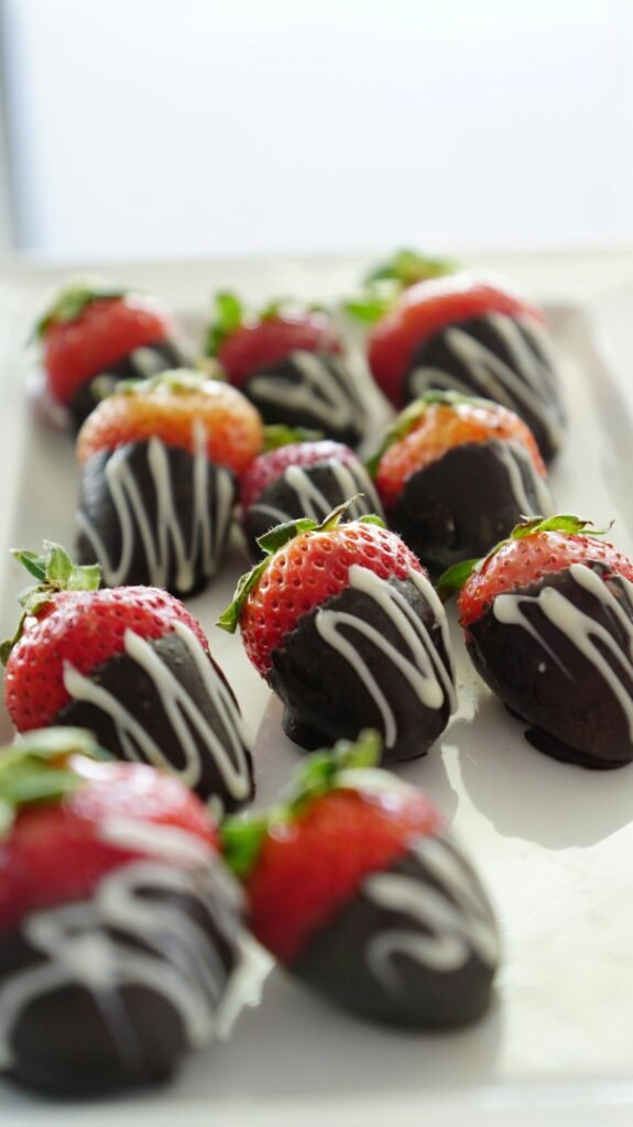 Chocolate-dipped strawberries with a chocolate drizzle on a plate