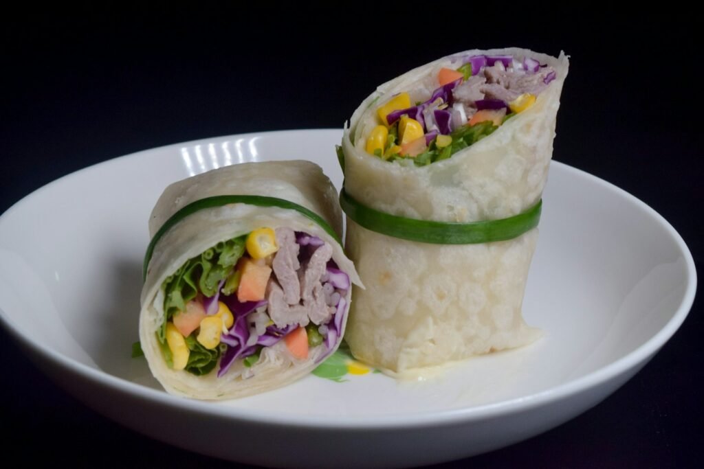 Veggie wrap cut in half showing shredded purple cabbage and fresh vegetables
