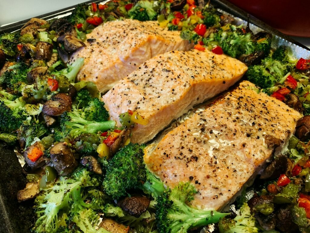 Roasted salmon fillets on a sheet pan with broccoli and vegetables