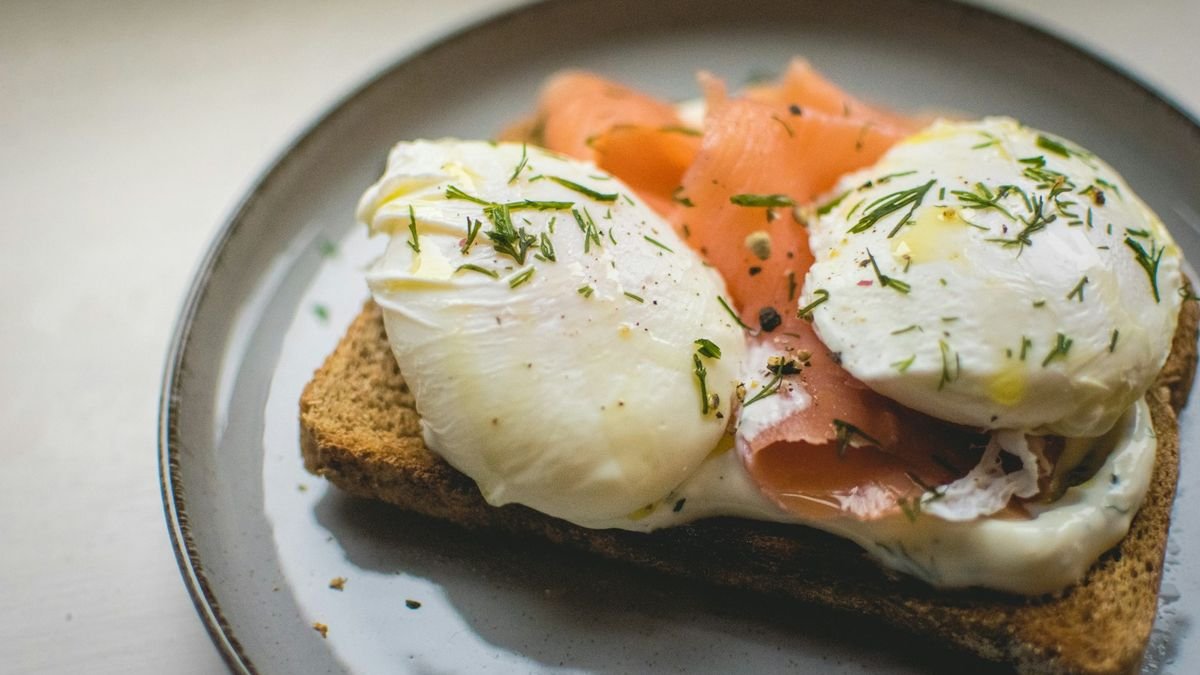 Two poached eggs with smoked salmon on whole-grain toast; fatty fish and egg yolks are among the few foods that naturally contain vitamin D
